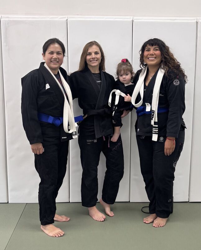 Academy members and a young child posing together in Gi
