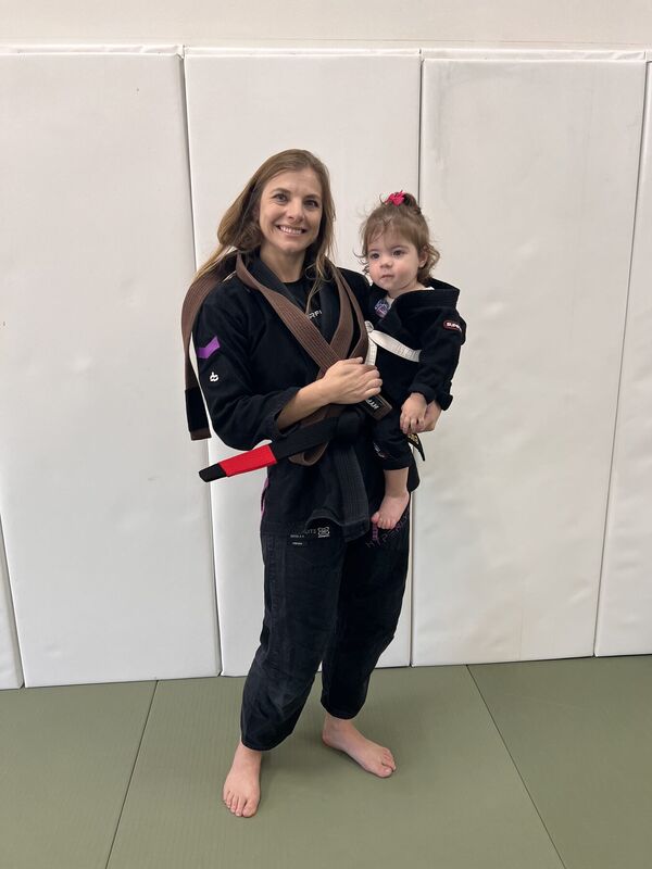 Academy member holding a child on the mats