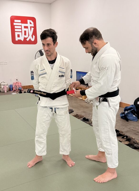 Two black belts standing together during a belt ceremony